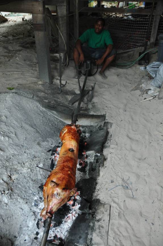 Preparando o jantar (o pobre porco) em rua de Caye Caulker, na grande barreira de corais, em Belize